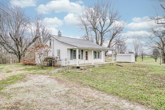 view of front of house with covered porch, a shed, and a front lawn