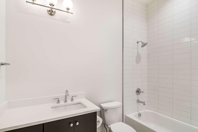 full bathroom featuring tiled shower / bath, vanity, and toilet