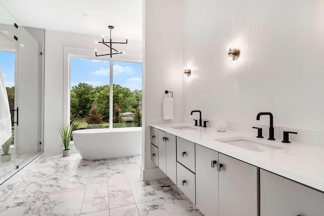 bathroom featuring a bathing tub, vanity, and a chandelier