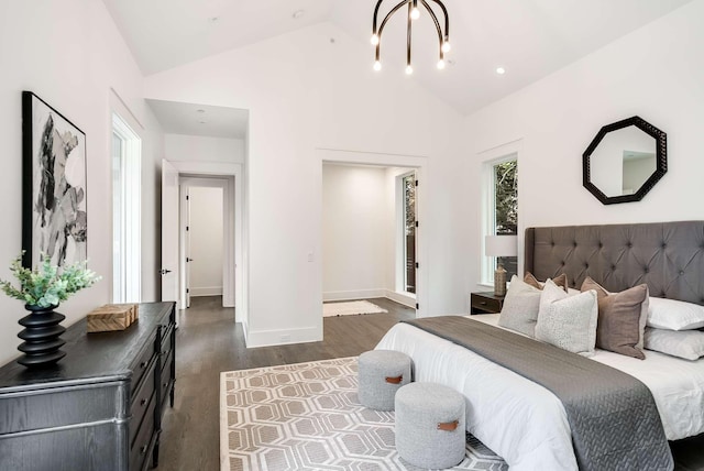 bedroom with dark hardwood / wood-style flooring, lofted ceiling, and a chandelier