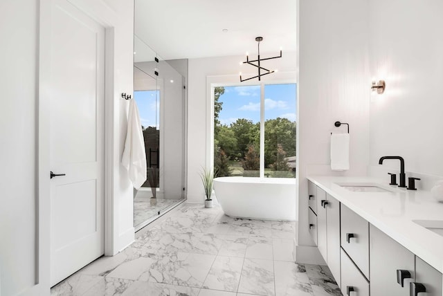 bathroom with a washtub, vanity, and an inviting chandelier