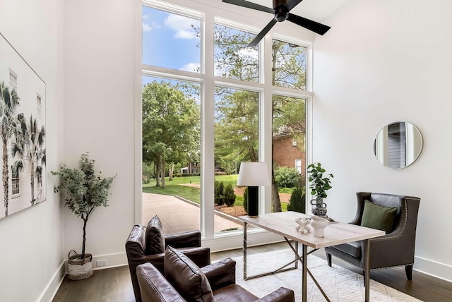 office space featuring a towering ceiling, ceiling fan, and dark wood-type flooring