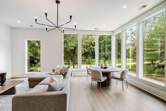 sunroom / solarium with plenty of natural light and a chandelier