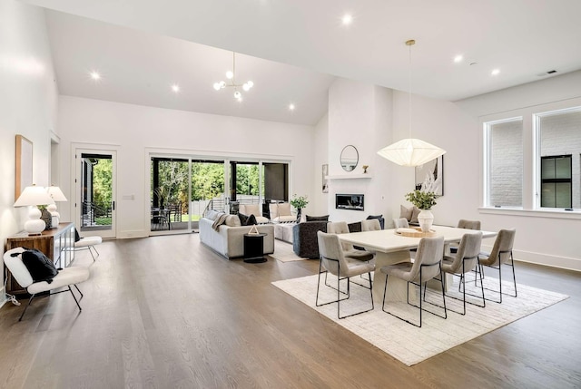 dining space featuring high vaulted ceiling, light hardwood / wood-style floors, and a notable chandelier