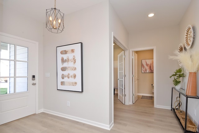 entryway featuring a chandelier and light hardwood / wood-style flooring