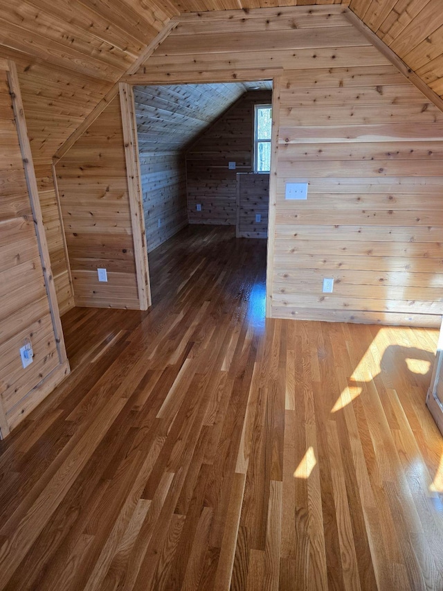 bonus room with wooden walls, wood-type flooring, vaulted ceiling, and wooden ceiling