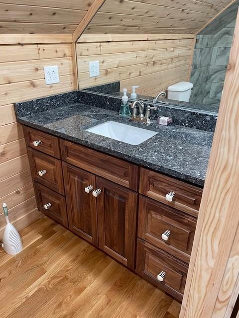 bathroom featuring wooden walls, vanity, wooden ceiling, and wood-type flooring