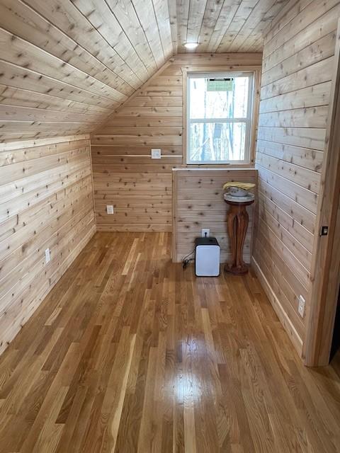 bonus room with wood-type flooring, vaulted ceiling, wooden walls, and wood ceiling