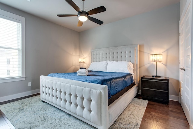 bedroom with multiple windows, ceiling fan, and dark wood-type flooring