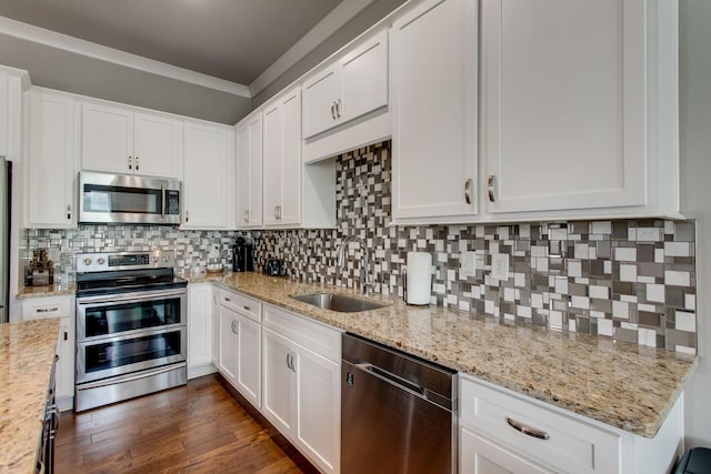 kitchen with sink, decorative backsplash, light stone counters, white cabinetry, and stainless steel appliances