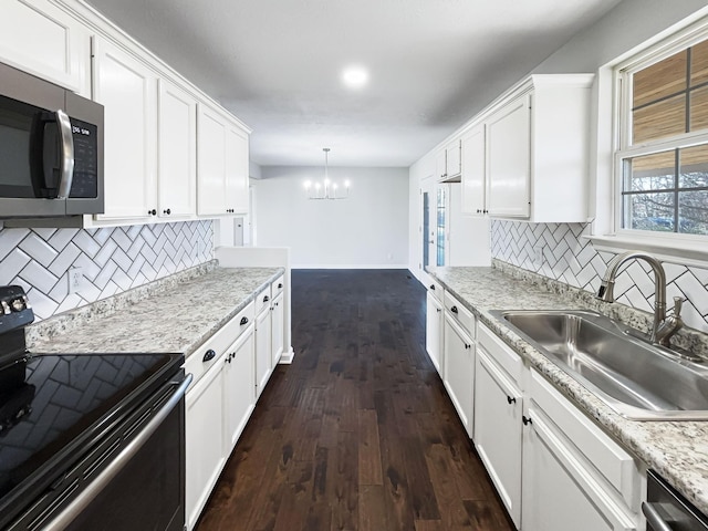 kitchen with white cabinets, sink, hanging light fixtures, and appliances with stainless steel finishes