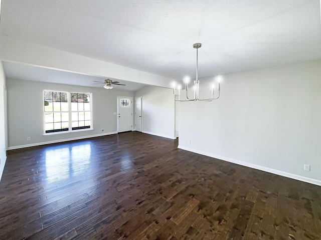 empty room with dark hardwood / wood-style flooring and ceiling fan with notable chandelier