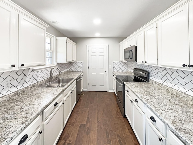 kitchen featuring black electric range oven, stainless steel dishwasher, sink, dark hardwood / wood-style floors, and white cabinetry