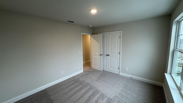 unfurnished bedroom with carpet flooring and a closet