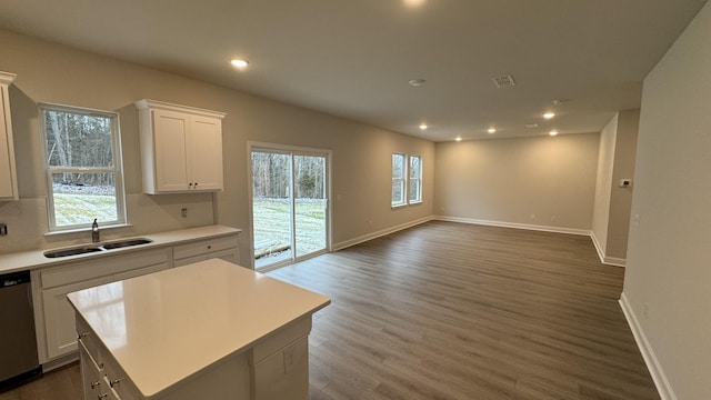 kitchen with white cabinets, a center island, stainless steel dishwasher, and sink