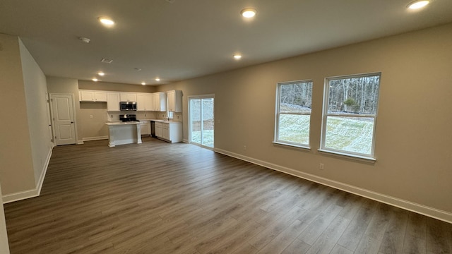 unfurnished living room with dark wood-type flooring