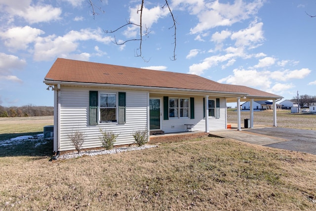 ranch-style home featuring a porch, central AC, a carport, and a front lawn