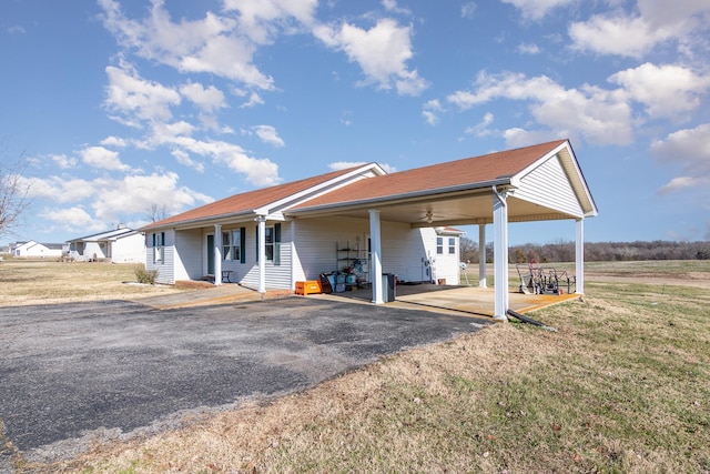 exterior space featuring ceiling fan, a yard, and a carport