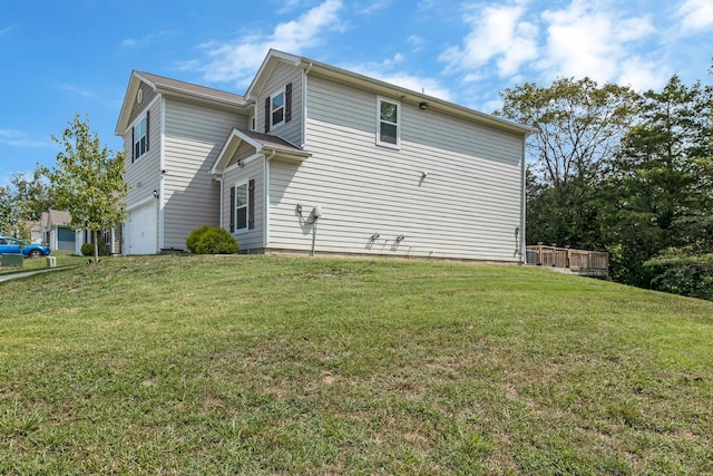 view of side of home with a lawn and a garage