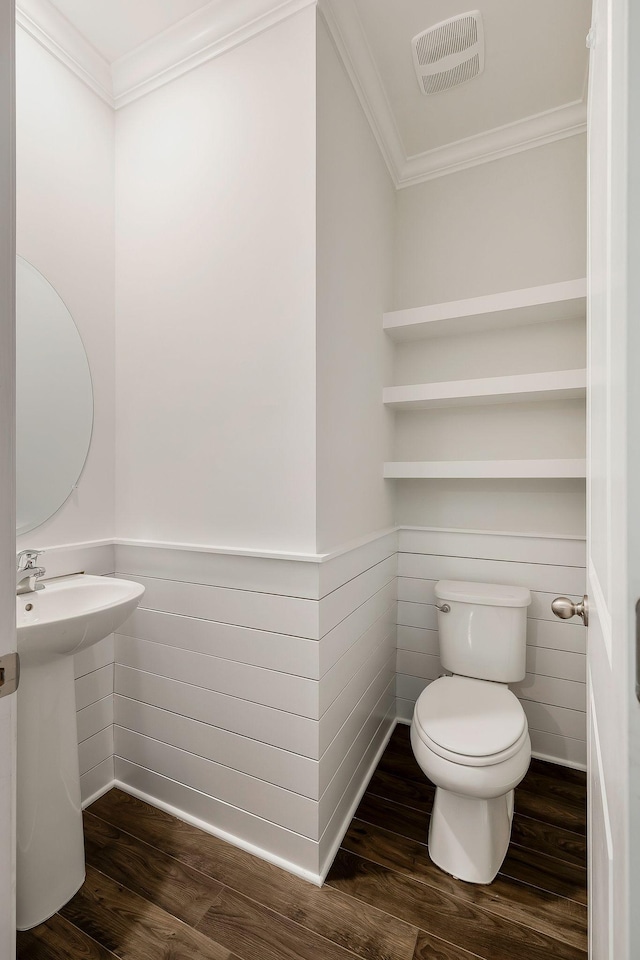 bathroom with crown molding, toilet, and hardwood / wood-style flooring