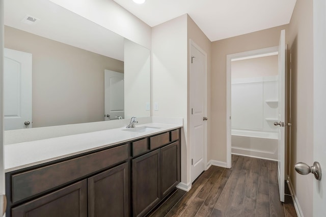 bathroom featuring vanity, wood-type flooring, and shower / washtub combination