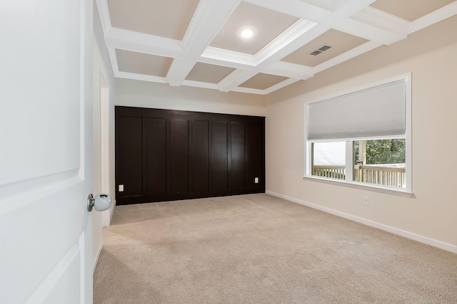 unfurnished bedroom featuring beam ceiling, light colored carpet, and coffered ceiling