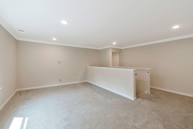 empty room featuring crown molding and light carpet