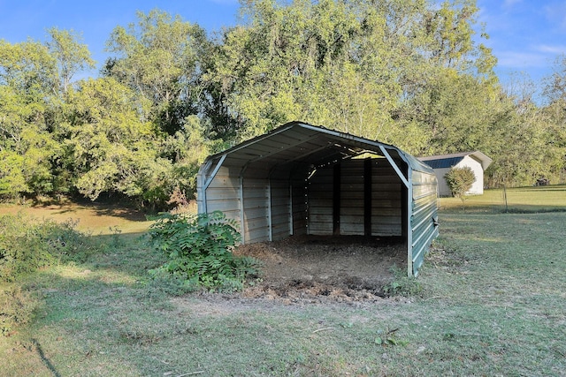 view of outdoor structure with a carport and a lawn