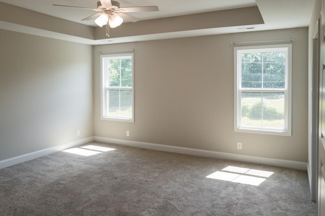 unfurnished room featuring a wealth of natural light, carpet, and ceiling fan