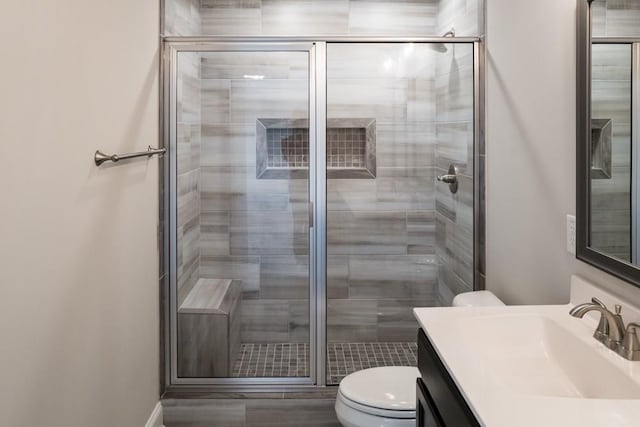 bathroom with vanity, an enclosed shower, and toilet