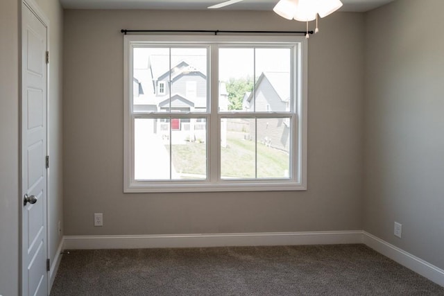 carpeted spare room featuring plenty of natural light and ceiling fan