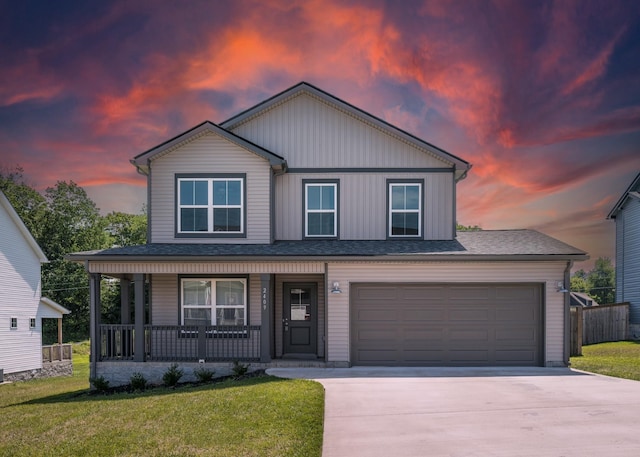 view of front of house featuring a porch, a yard, and a garage