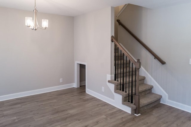 stairs featuring a chandelier and wood-type flooring