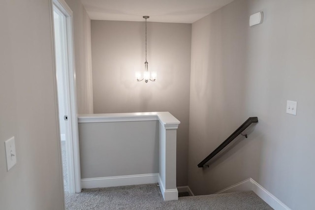 stairway featuring carpet and a chandelier