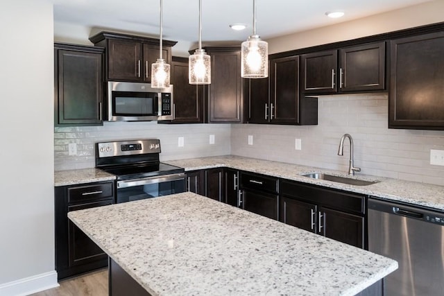 kitchen featuring appliances with stainless steel finishes, dark brown cabinets, pendant lighting, and sink