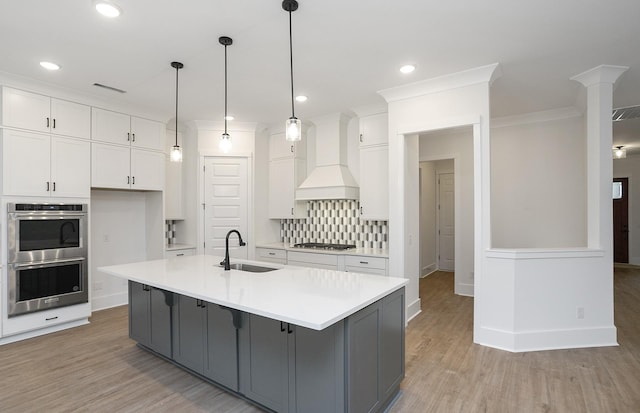 kitchen featuring custom exhaust hood, a large island, stainless steel appliances, white cabinets, and sink