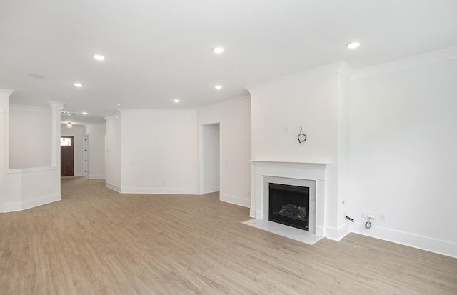 unfurnished living room with ornamental molding and light wood-type flooring