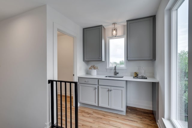 kitchen featuring sink, gray cabinetry, and light wood-type flooring