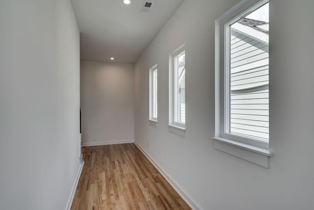 corridor with a healthy amount of sunlight and light hardwood / wood-style floors