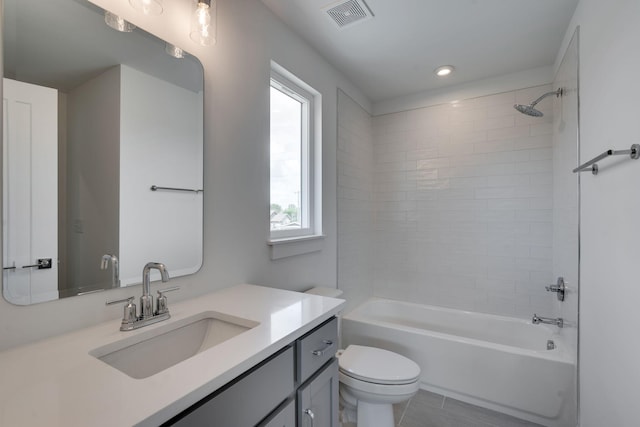 full bathroom with vanity, tiled shower / bath, and toilet