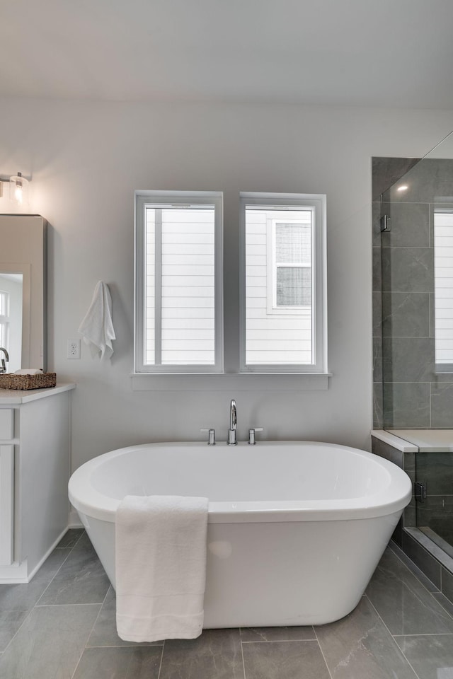 bathroom featuring vanity and independent shower and bath