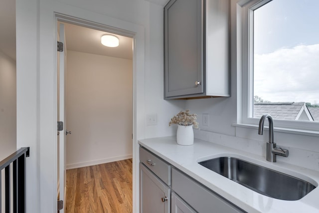 kitchen featuring gray cabinets, sink, and light hardwood / wood-style floors