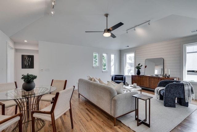 living room with lofted ceiling, ceiling fan, and light hardwood / wood-style flooring