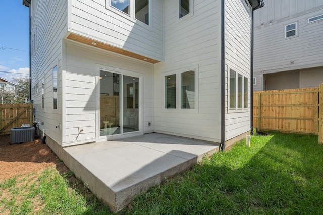 back of property featuring a lawn, cooling unit, and a patio area