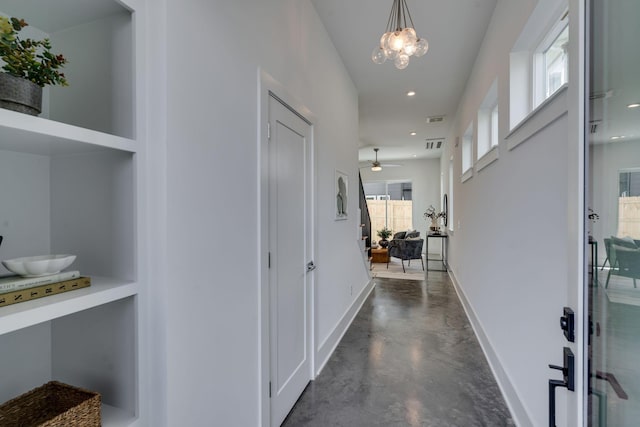 hall featuring an inviting chandelier