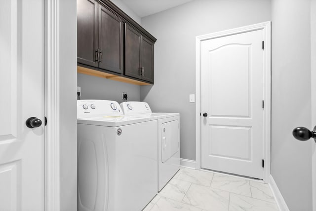 laundry room with separate washer and dryer and cabinets