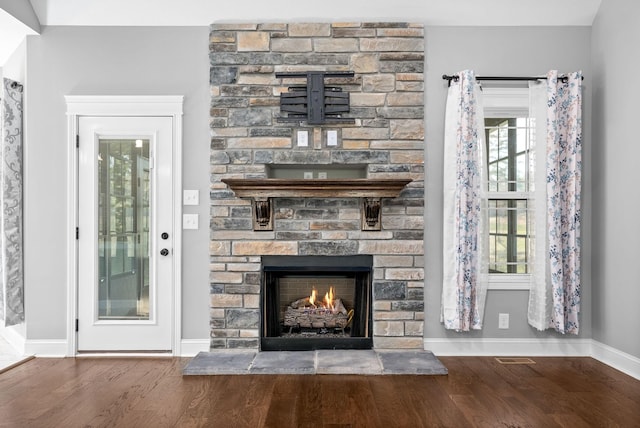 unfurnished living room featuring a stone fireplace and wood-type flooring