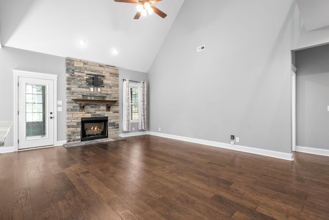 unfurnished living room with plenty of natural light, ceiling fan, wood-type flooring, and high vaulted ceiling