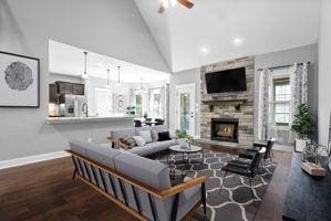 living room with ceiling fan, a fireplace, high vaulted ceiling, and wood-type flooring