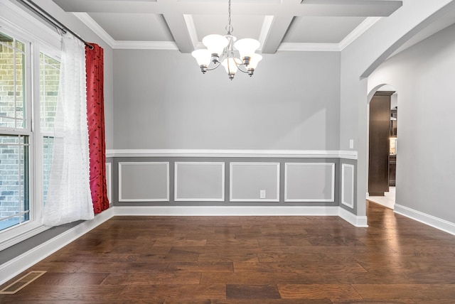 empty room featuring beam ceiling, dark wood-type flooring, coffered ceiling, and a notable chandelier